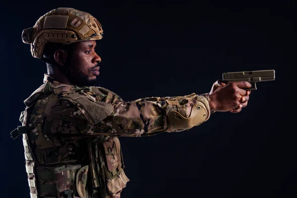American man in camouflage suit aiming with a pistol studio shot — Stock Photo, Image
