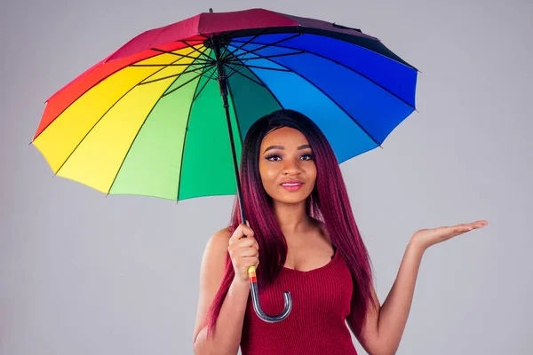portrait african american beautiful woman creative hair coloring dye purple color on white background in studio black heels shoes cotton dress knitwear holding a bright colored umbrella in hand
