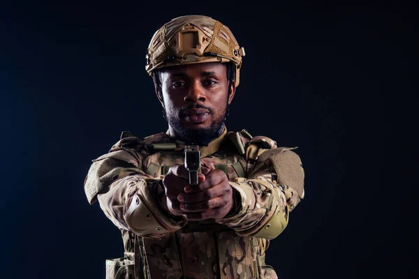 Hombre americano en traje de camuflaje apuntando con una pistola de tiro de estudio — Foto de Stock