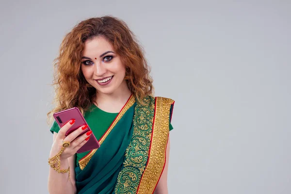 Schöne und junge indische Geschäftsfrau in traditionellem indischen Sari, die mit einem Smartphone-Telefon arbeitet.asiatische Studentin arbeitet freiberuflich. — Stockfoto