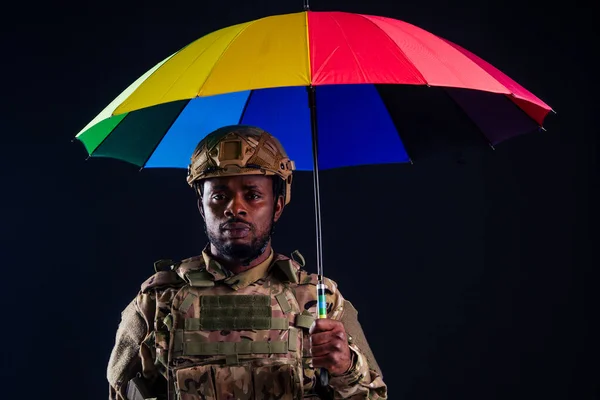 Ejército militar africano guerrero traje de camuflaje tristeza envuelto en una bandera americana negro fondo estudio, mintiendo violencia noticias criminal medios de comunicación — Foto de Stock