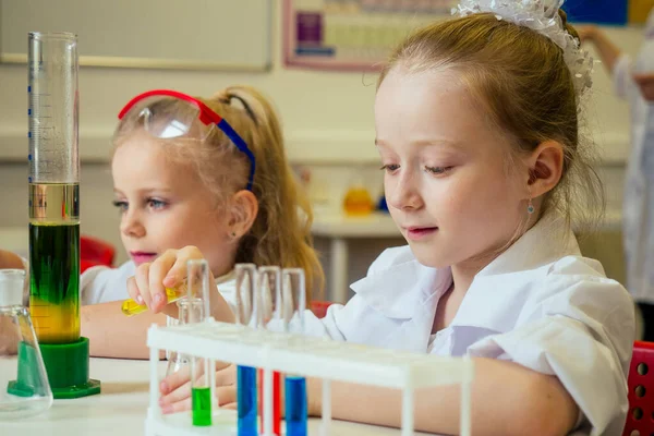 two blonde chemist school kid student little girls girlfriend sisters chemical experiment white medical gown classroom science