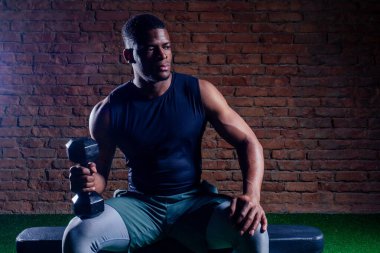 Kas yığını Afrikalı Amerikalı adam dambılla egzersiz yapıyor.