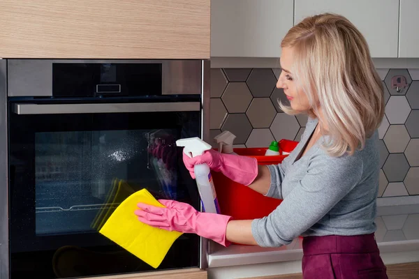 Giovane donna forno di pulizia in cucina — Foto Stock