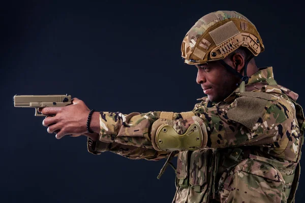 American man in camouflage suit aiming with a pistol — Stock Photo, Image