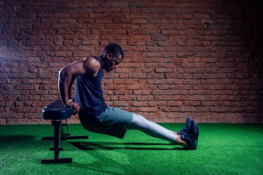 Spor salonunda karın kasları için egzersiz yapan bir sporcu.