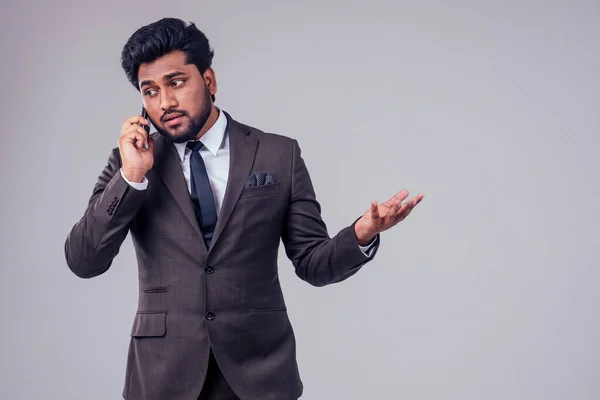 Success handsome Arabian businessman classic suit talking by phone in white studio background — Stock fotografie