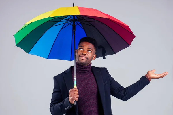 Homem de negócios sorridente em lã casaco terno com multi-colorido guarda-chuva estúdio de fundo branco — Fotografia de Stock