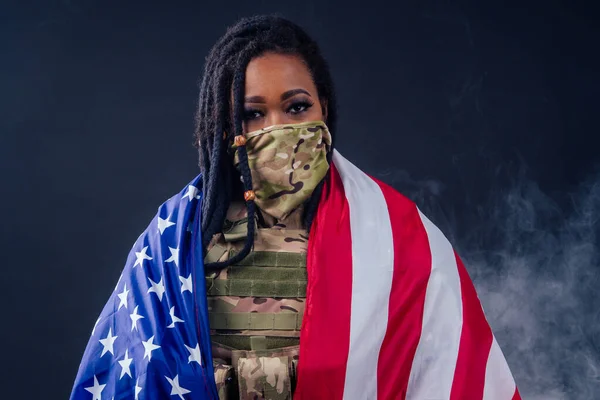 afro american army latin soldier in camouflage clothes dreadlocks makeup and big lips on black background smoke in studio with american flag,independence day usa 4th of july