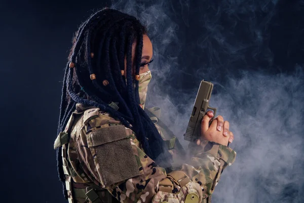 afro american indian army latin soldier in camouflage clothes hair dreadlocks evening makeup in mask on a black background in the studio