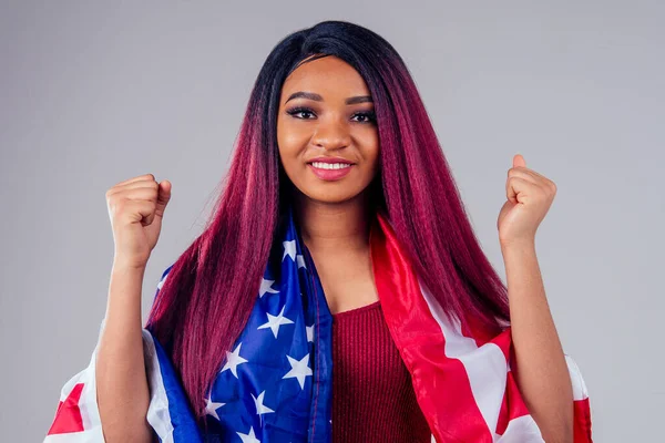 woman with pink purple black hair cowered with american flag studio white background