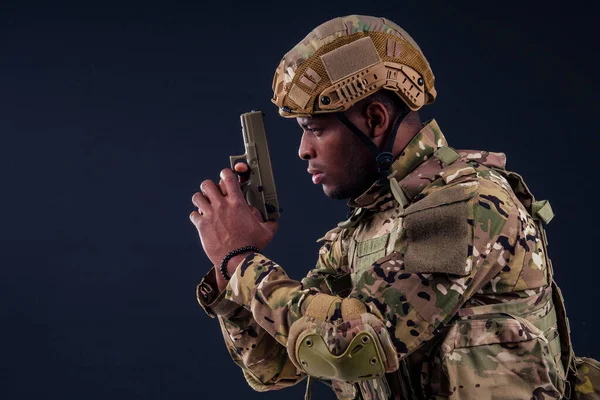 Hombre americano en traje de camuflaje apuntando con una pistola — Foto de Stock