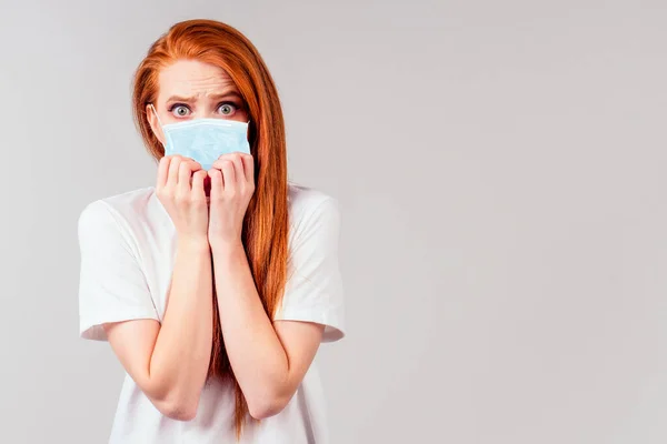 Pelirroja pelirroja mujer sintiéndose infeliz y usando máscara médica — Foto de Stock