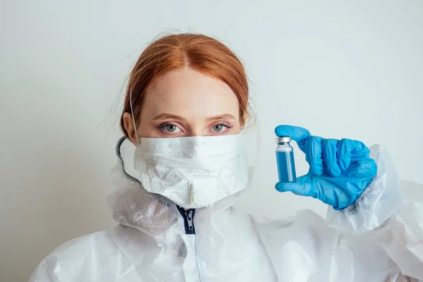 Mulher virologista em máscara de proteção química, óculos e luvas segurando vacina potencial no laboratório — Fotografia de Stock