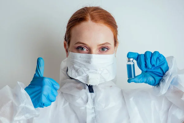 Mulher virologista em máscara de proteção química, óculos e luvas segurando vacina potencial no laboratório — Fotografia de Stock