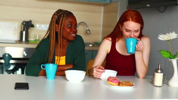 Afroamerykanka słucha rudej dziewczyny w kuchni — Wideo stockowe