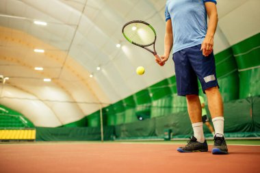 Eğitmen ya da koç içeride tenis oynamayı öğretiyor.