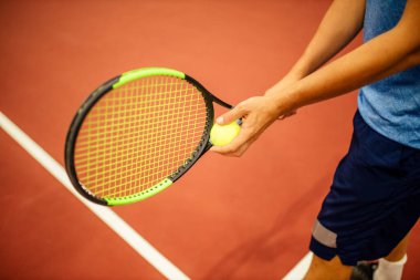 Eğitmen ya da koç içeride tenis oynamayı öğretiyor.