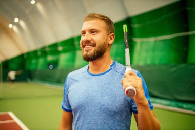 Eğitmen ya da koç içeride tenis oynamayı öğretiyor.