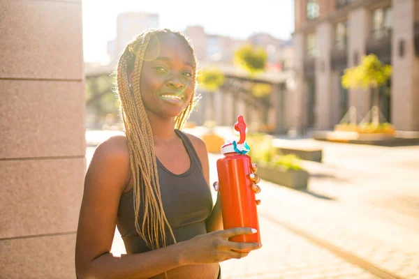 Afroamerikanerin trinkt Smoothies nach dem Joggen in der Innenstadt — Stockfoto