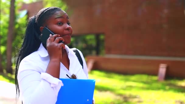 Красива усміхнена молода африканська жінка в білій футболці і тримає копію — стокове відео