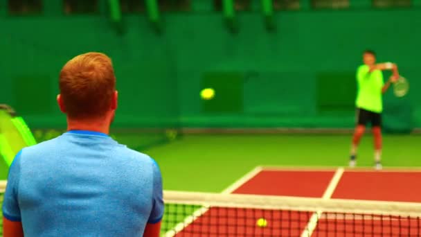 Jóvenes jugando a la enseñanza juegan al tenis en interiores — Vídeos de Stock