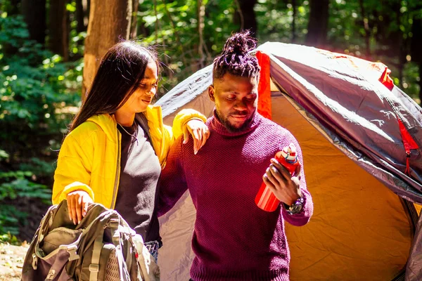 Afro americano misto casal estabelecendo instalação de uma barraca e tendo um tempo de descanso ao ar livre — Fotografia de Stock