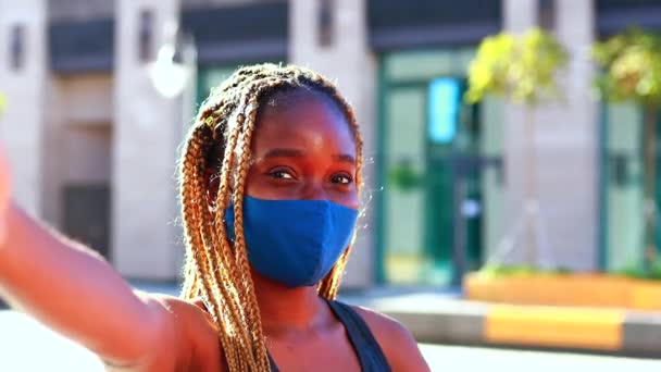 Afro kobieta w dresie i maska medyczna robi sobie selfie na ulicy. — Wideo stockowe