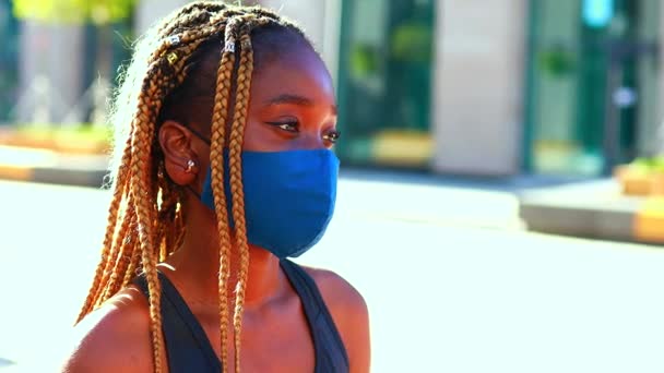 En snotty afro flicka står på gatan bär en mask under coronavirus. — Stockvideo