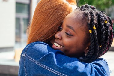 Kızıl saçlı kadın ve kız arkadaşı sokakta yürüyorlar.