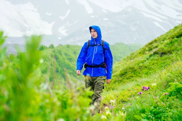Homme en veste bleue avec pluie en montagne — Photo