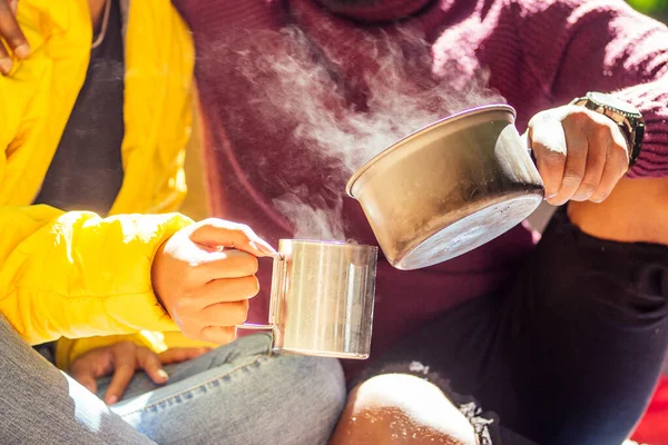 Hombre afroamericano y mujer hispana bebiendo té, cocinando comida en un quemador de gas — Foto de Stock