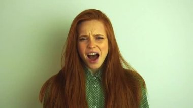 Yeşil tişörtlü kızıl saçlı kadın üzgün ve stresli.