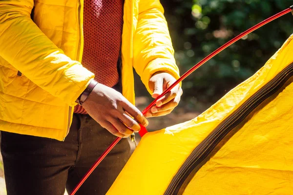 Africano americano en amarillo jacker poner en un tienda en bosque — Foto de Stock