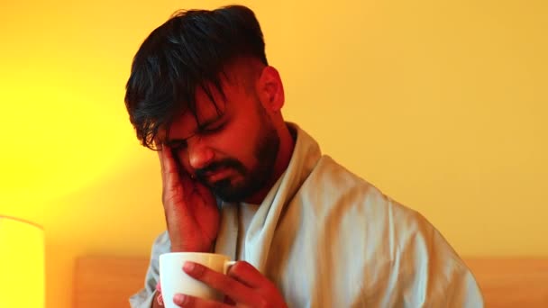 Tengo fiebre. Un indio bebiendo una taza de té caliente en casa. — Vídeos de Stock