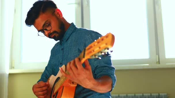 インド人男性がギターを弾いてお気に入りの歌を歌っています — ストック動画