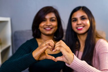 Arap kadınlar oturma odasında kanepede oturuyor.