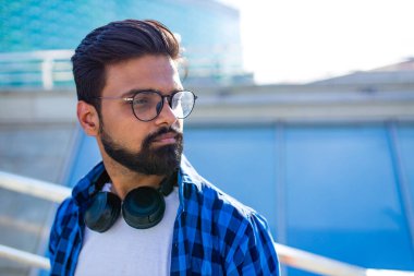 Yakışıklı, sakallı, esmer, Arap bir adam açık hava müziklerini dinliyor.