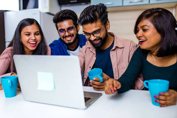 Indian four people in kitchen looking at laptop and discussing a homework distance learning — Stock Photo, Image