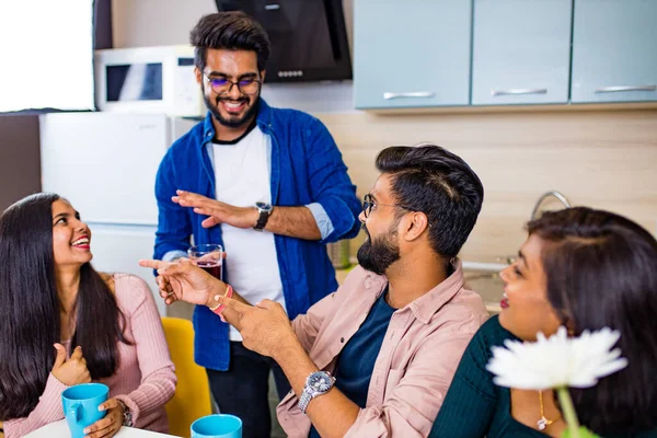 Arabian men and women sitting in kitchen and discussing a news — Stock Photo, Image