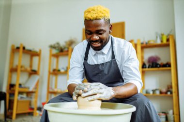 Melez yarış adamı çömlek atölyesinde vazo yapıyor.