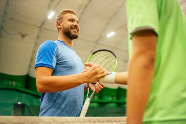 Eğitmen ya da koç içeride tenis oynamayı öğretiyor.