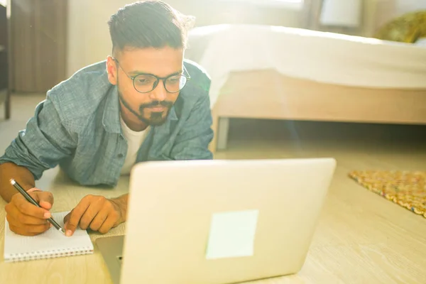 Distância casa conceito de aprendizagem indiana masculino fazendo trabalho em casa na sala de estar negócio start up — Fotografia de Stock