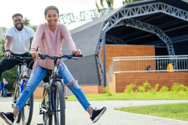 Kiralık telefon uygulamasında bisiklet süren melez bir çift.