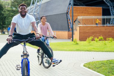 Kiralık telefon uygulamasında bisiklet süren melez bir çift.