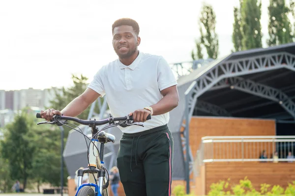 Concepto de ecología y transporte. moderno joven afroamericano hombre de negocios ciclismo para trabajar en bicicleta — Foto de Stock