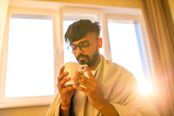 Άραβας Ινδός άνδρας πίνοντας ζεστό τσάι λεμονιού dinder masala στο πρωινό υπνοδωμάτιο, ενώ το αίσθημα κρύο καλύπτεται με μια κουβέρτα — Φωτογραφία Αρχείου
