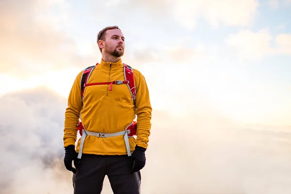 Homem no topo da montanha. Cena conceitual no nevoeiro ao pôr do sol — Fotografia de Stock