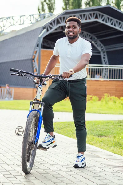 Concepto de ecología y transporte. moderno joven afroamericano hombre de negocios ciclismo para trabajar en bicicleta — Foto de Stock