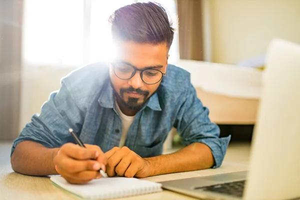 Distância casa conceito de aprendizagem indiana masculino fazendo trabalho em casa na sala de estar negócio start up — Fotografia de Stock